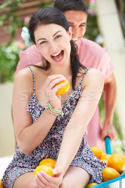 Homem empurrando mulher carrinho de mão laranjas mulheres Foto stock © monkey_business