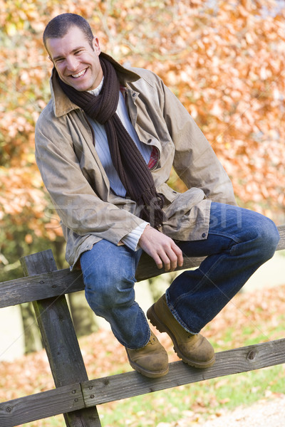 Joven sesión cerca hojas de otoño detrás árbol Foto stock © monkey_business