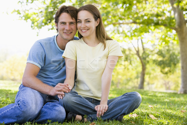 Stock photo: Couple sitting outdoors smiling