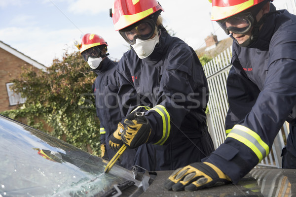 Firefighters breaking a car windscreen to help a car crash victi Stock photo © monkey_business