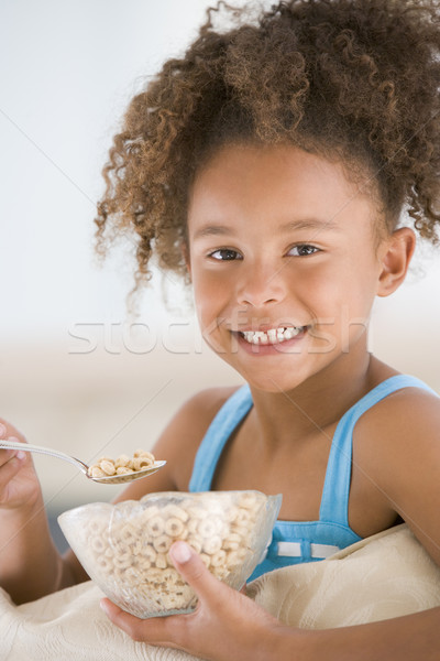 Young girl eating cereal in living room smiling Stock photo © monkey_business
