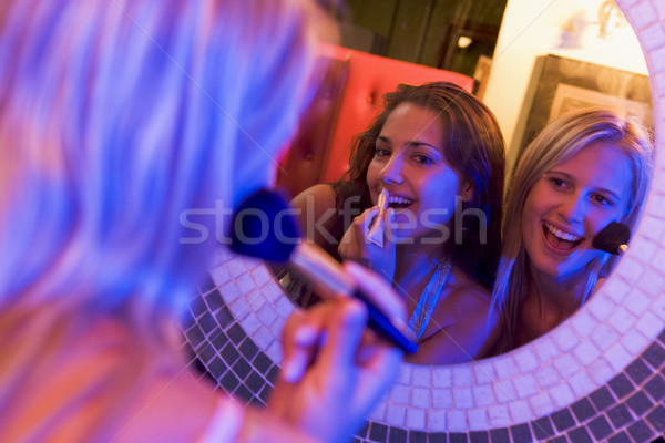 Two young women applying makeup in a nightclub bathroom Stock photo © monkey_business