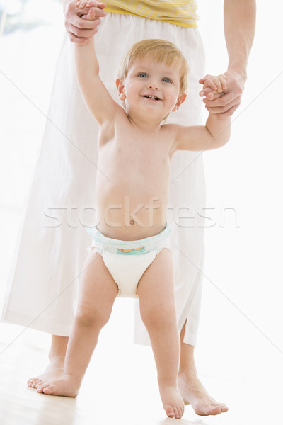 Mother helping baby walk indoors smiling Stock photo © monkey_business