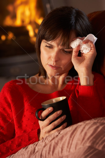 Sick Woman With Cold Resting On Sofa By Cosy Log Fire Stock photo © monkey_business