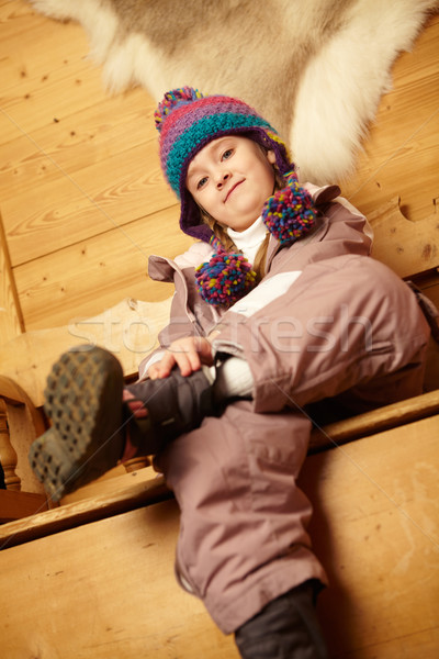 Young Girl Sitting On Wooden Seat Putting On Warm Outdoor Clothe Stock photo © monkey_business