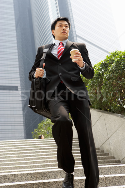 Chinese Businessman Rushing Down Steps Carrying Bag And Takeaway Stock photo © monkey_business