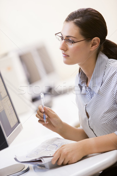 Woman in computer room circling items in a newspaper Stock photo © monkey_business