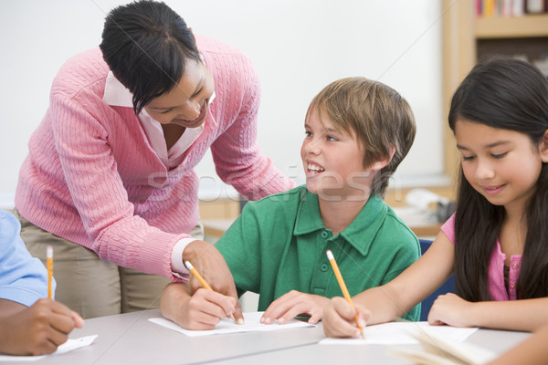 Teacher and pupil in elementary school classroom Stock photo © monkey_business