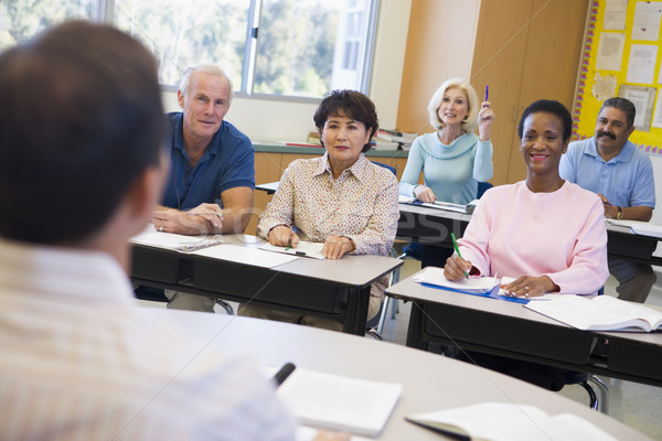 Mature female student raising hand in class Stock photo © monkey_business