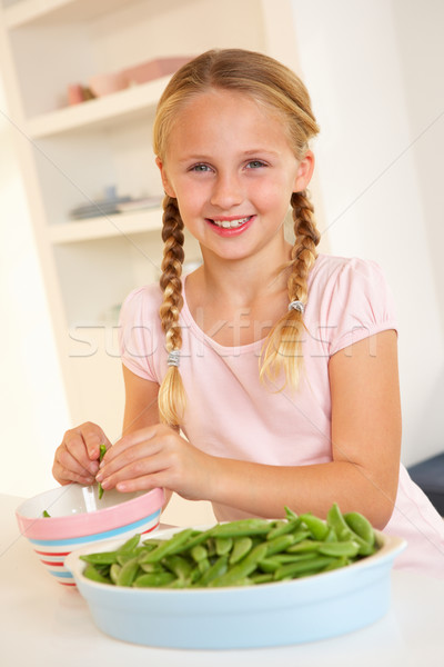 Happy girl splitting peas in kitchen Stock photo © monkey_business