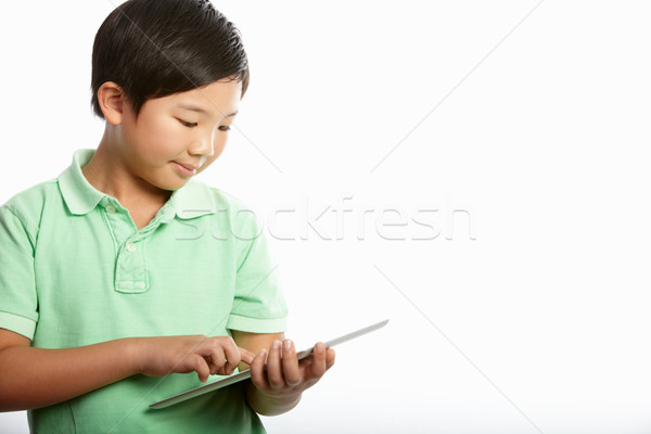 Stock photo: Studio Shot Of Chinese Boy With Digital Tablet