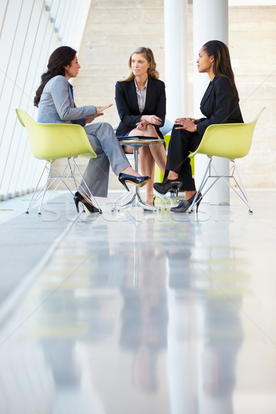 Three Businesswomen Meeting Around Table In Modern Office Stock photo © monkey_business