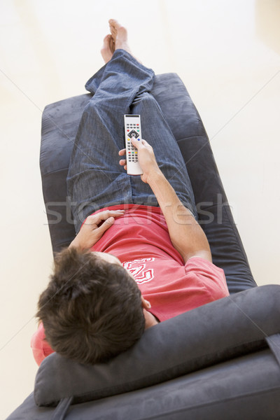 Man sitting in chair using remote control Stock photo © monkey_business