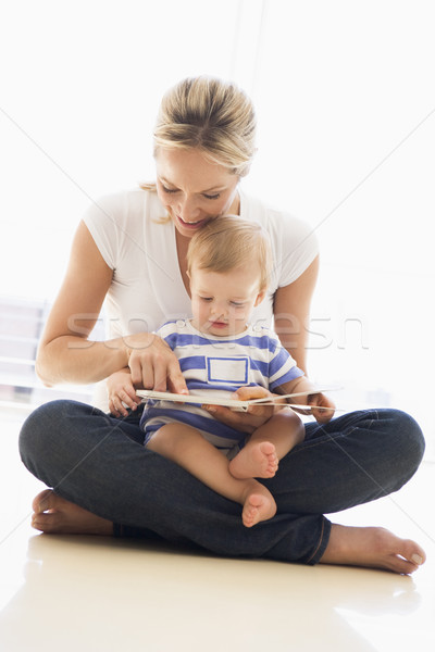 Stock photo: Mother and baby indoors reading book and smiling