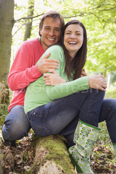 Couple outdoors in woods sitting on log smiling Stock photo © monkey_business
