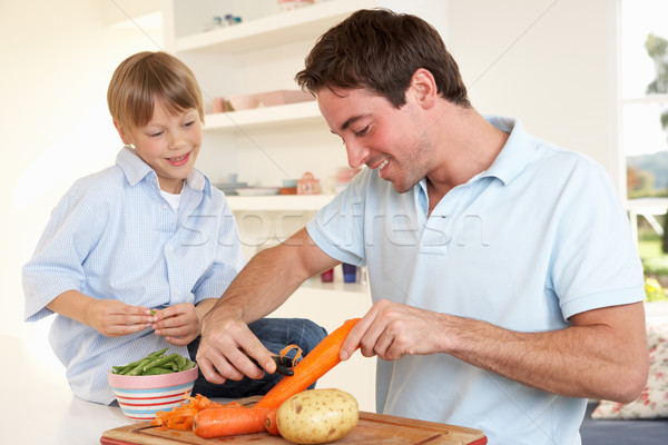 Happy young man with boy peeling vegetables in kitchen Stock photo © monkey_business