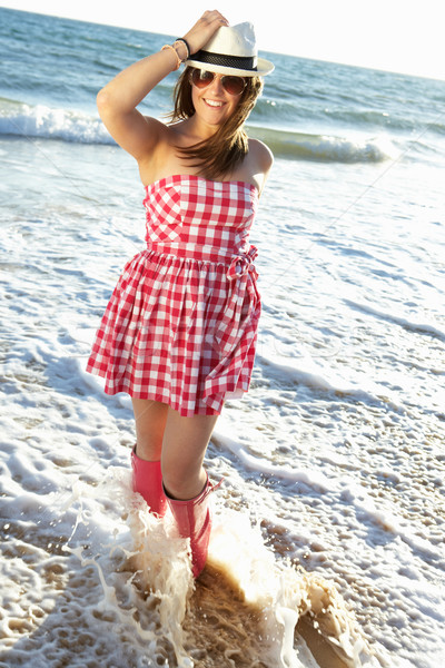 Teenage Girl Wearing Wellington Boots Splashing In Sea On Beach  Stock photo © monkey_business