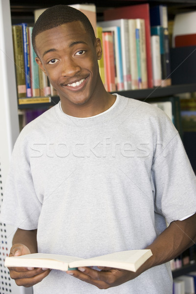 Stock photo: Male college student reading in a library