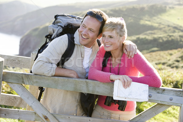 Stock photo: Couple on cliffside outdoors leaning on railing and smiling