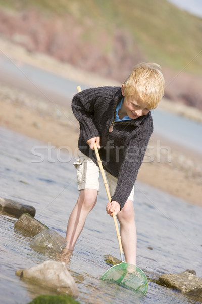 Young boy at beach with net smiling Stock photo © monkey_business