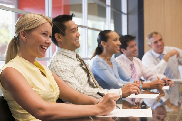 Five businesspeople at boardroom table smiling Stock photo © monkey_business