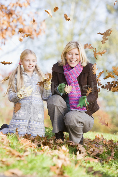 Mother and daughter throwing leaves in the air Stock photo © monkey_business