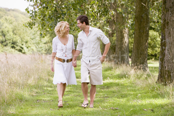 Stock photo: Couple walking on path holding hands smiling