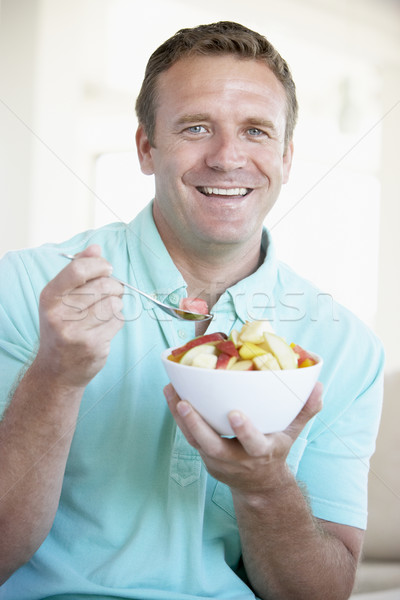 Adulte homme manger fruits frais salade maison [[stock_photo]] © monkey_business