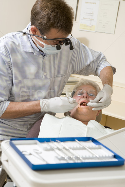 Dentist in exam room with woman in chair Stock photo © monkey_business