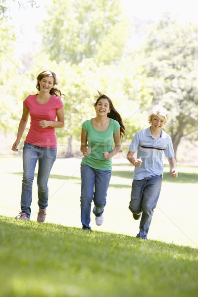 Stock photo: Teenagers Running Through Park