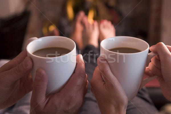 Feet warming at fireplace with hands holding coffee Stock photo © monkey_business