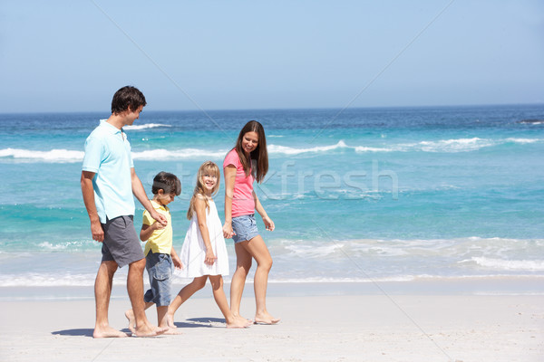 Stock photo: Family Walking Along Sandy Beach