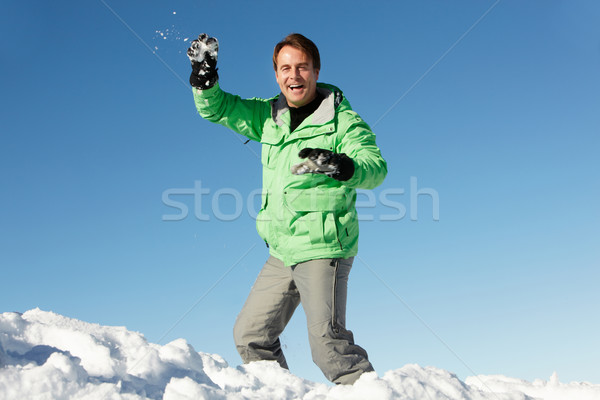 Man About To Throw Snowball Wearing Warm Clothes On Ski Holiday  Stock photo © monkey_business