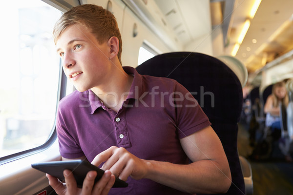 Fiatalember olvas könyv vonat utazás technológia Stock fotó © monkey_business