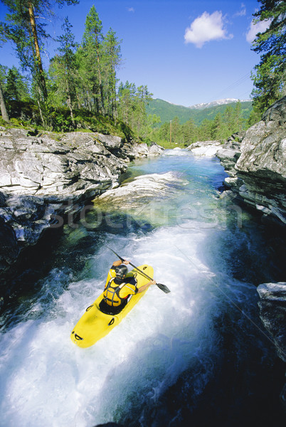 Stock photo: Young man kayaking in river