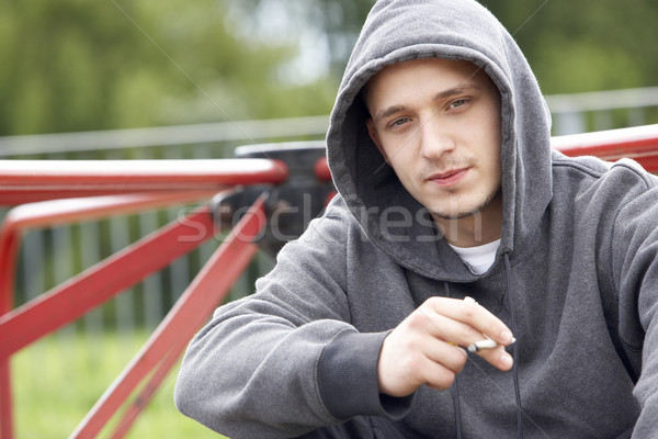 Fiatalember ül játszótér dohányzás ízület férfi Stock fotó © monkey_business