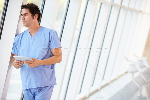 Stock photo: Doctor Using Digital Tablet In Corridor Of Modern Hospital