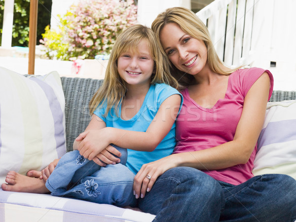 Woman and young girl sitting on patio smiling Stock photo © monkey_business