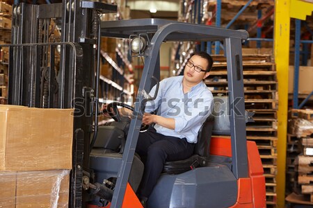 Warehouse worker standing by forklift Stock photo © monkey_business