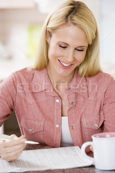 Woman in kitchen with newspaper and coffee smiling Stock photo © monkey_business
