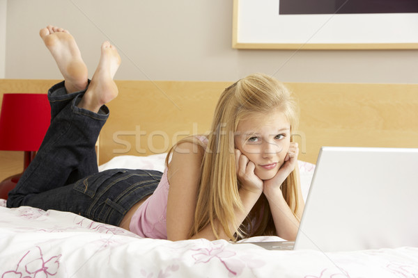 Tienermeisje met behulp van laptop slaapkamer gezicht laptop technologie Stockfoto © monkey_business