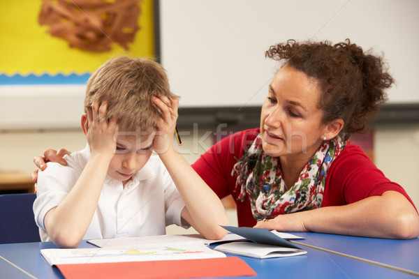Stressed Schoolboy Studying In Classroom With Teacher Stock photo © monkey_business