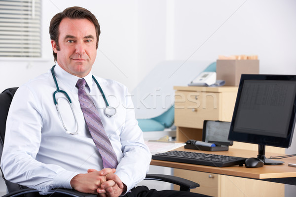 Portrait UK doctor sitting at desk Stock photo © monkey_business