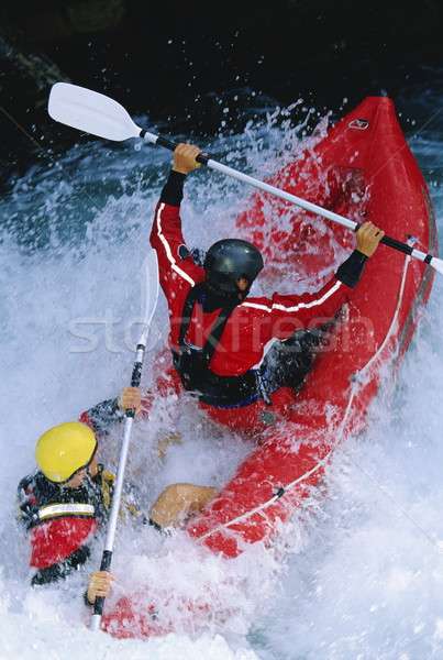 Two people paddling inflatable boat down rapids Stock photo © monkey_business