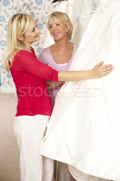 Bride trying on wedding dress with sales assistant Stock photo © monkey_business
