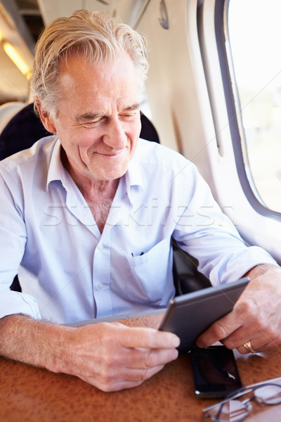 Senior Man Reading E Book On Train Journey Stock photo © monkey_business