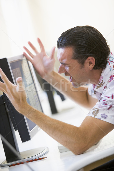 Man in computer room frustrated at monitor Stock photo © monkey_business