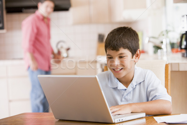 Young boy in kitchen with laptop and paperwork smiling with man  Stock photo © monkey_business