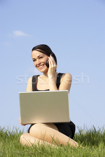 Foto stock: Mujer · usando · la · computadora · portátil · teléfono · móvil · aire · libre · ordenador