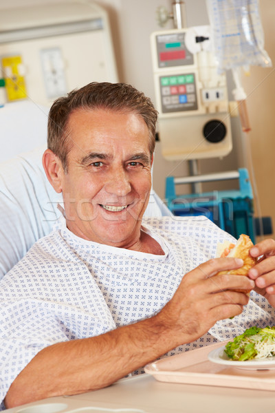Stock photo: Male Patient Enjoying Meal In Hospital Bed